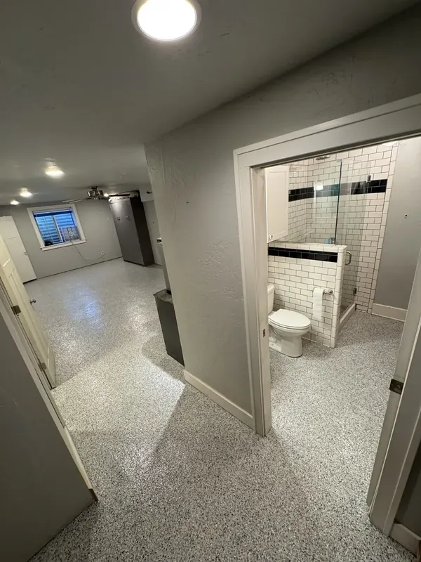 Clean, finished basement floor with polyaspartic coating creating a livable, moisture-resistant surface