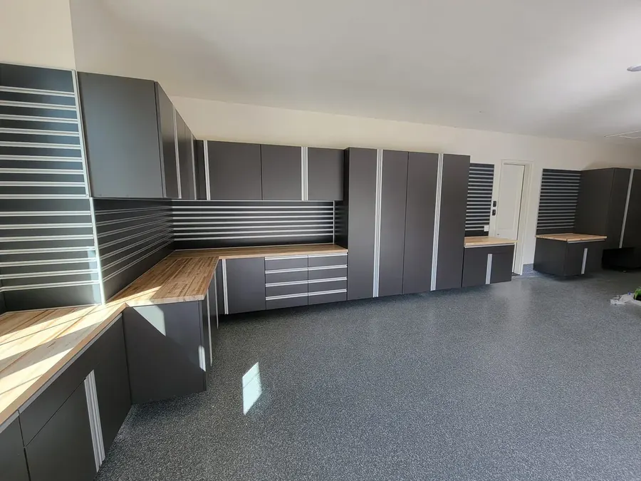 Powder-coated steel garage cabinets installed alongside a polyaspartic floor